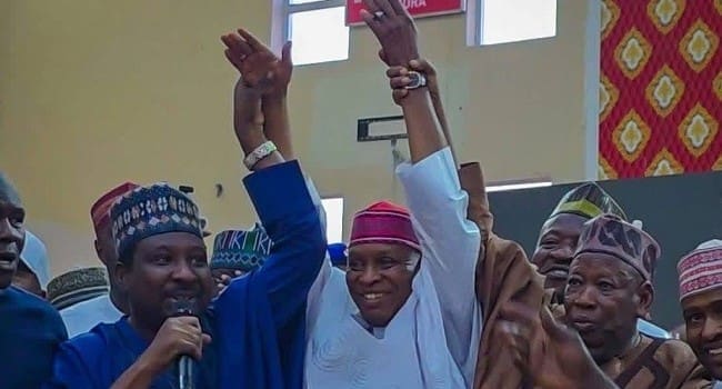 Deputy Senate President Barau Jubrin and Ex-APC Chairman Abdullahi Ganduje raise Gov Yusuf’s hands as he formerly defected to the APC on Monday, Januray 26, 2026.